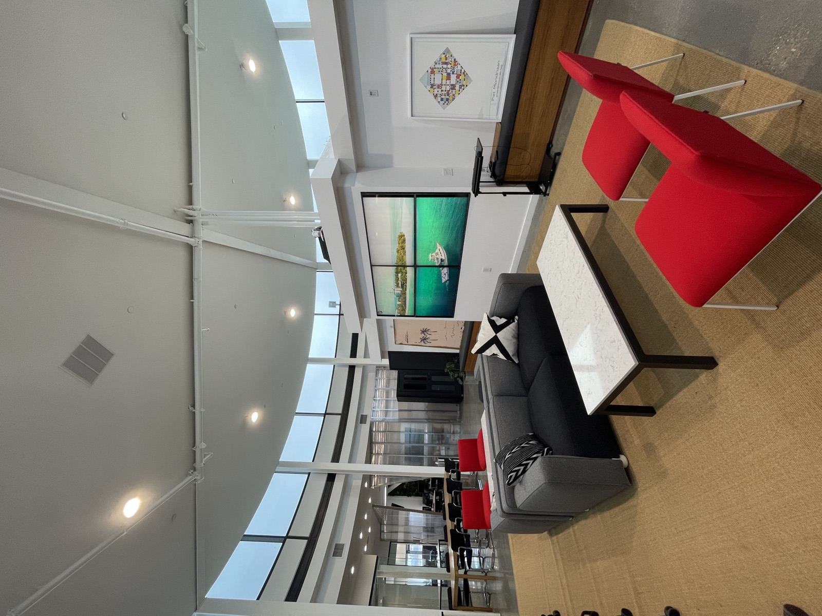 Lounge with red chairs and the office video wall