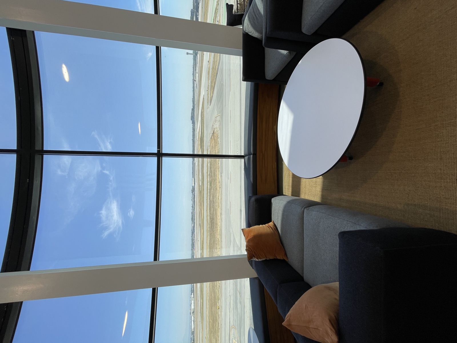 Lounge seating inside Circle’s glass-walled office, looking out over the Long Beach Airport runways